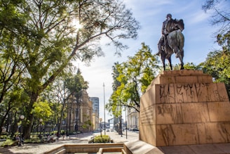 man riding horse statue near trees during daytime