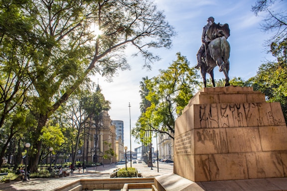 man riding horse statue near trees during daytime