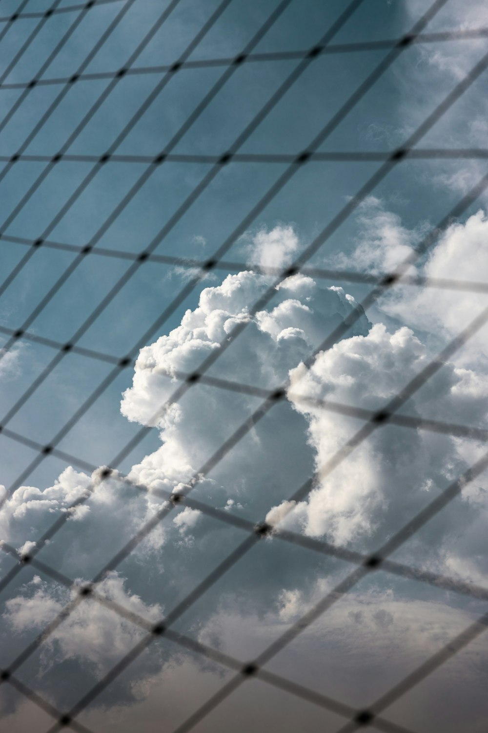 a plane flying through a cloudy blue sky