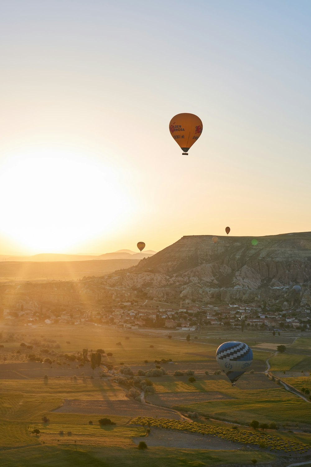 hot air balloons flying over the mountains during sunset