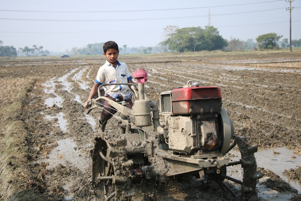 Man in white t-shirt and blue denim jeans riding on red and black tractor  during photo – Free Bangladesh Image on Unsplash