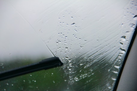 Close-up of a technician fitting a new windscreen wiper blade on a car.