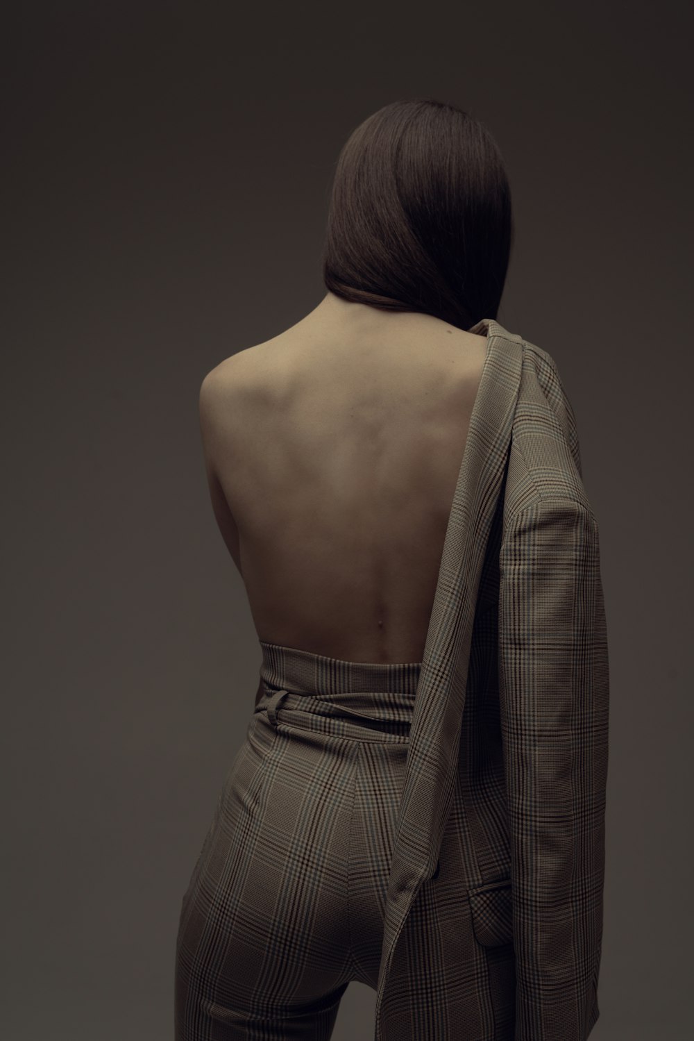 a woman in a suit with her back to the camera