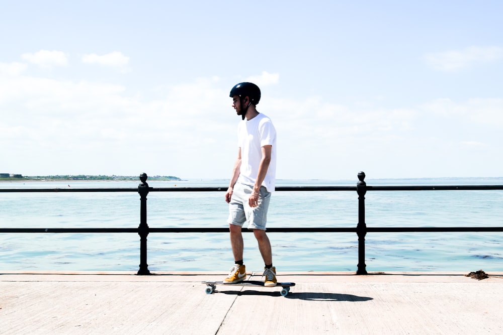 uomo in camicia bianca in piedi sul molo durante il giorno