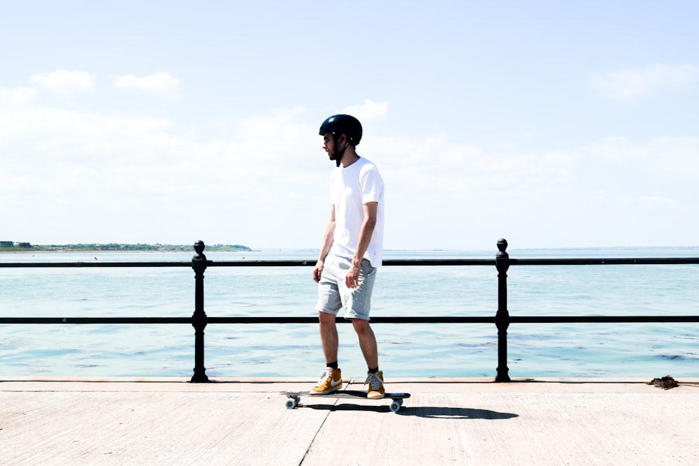 homme en chemise blanche debout sur le quai pendant la journée