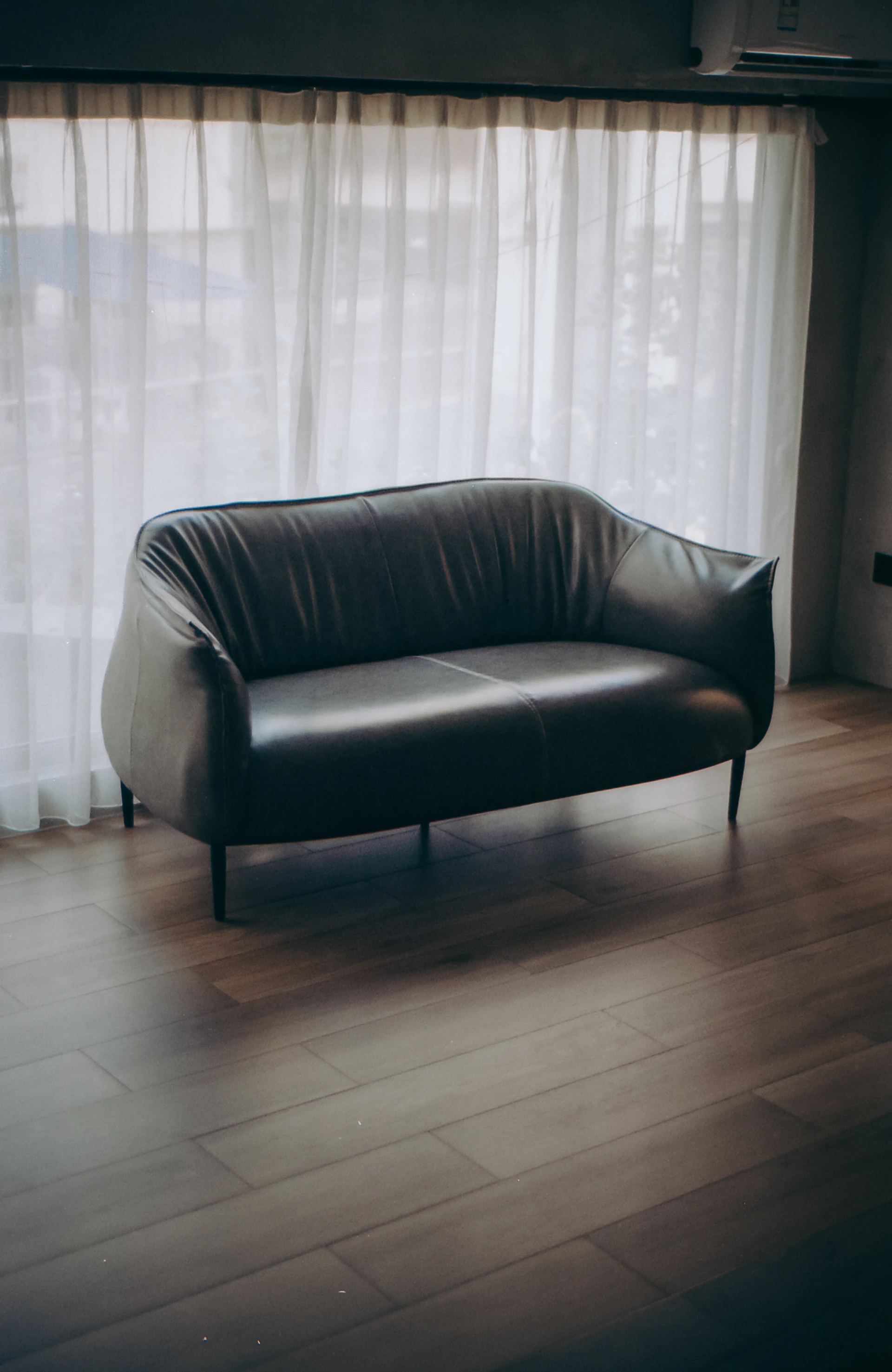 black leather sofa chair on brown wooden floor