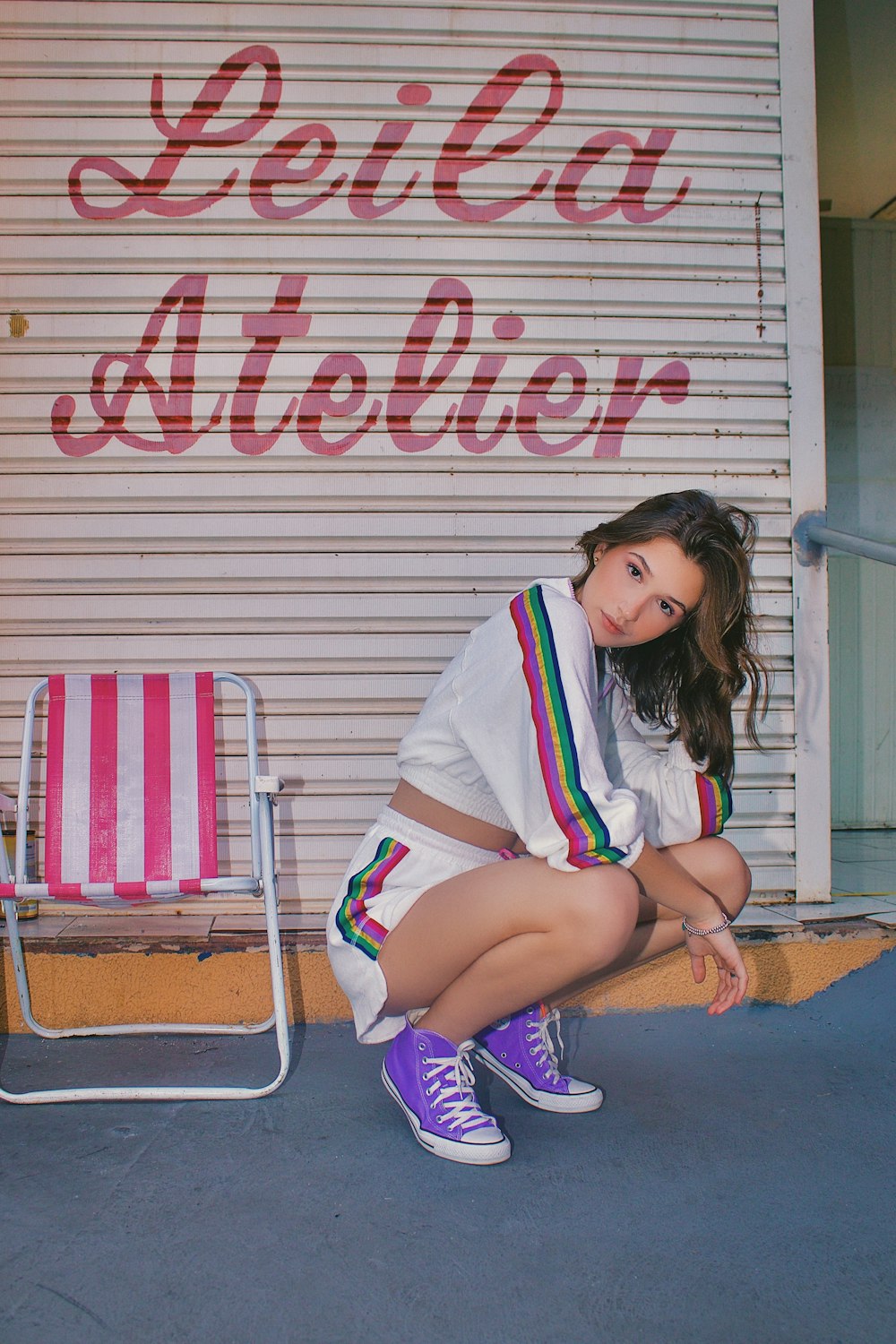 a woman sitting on a chair in front of a building