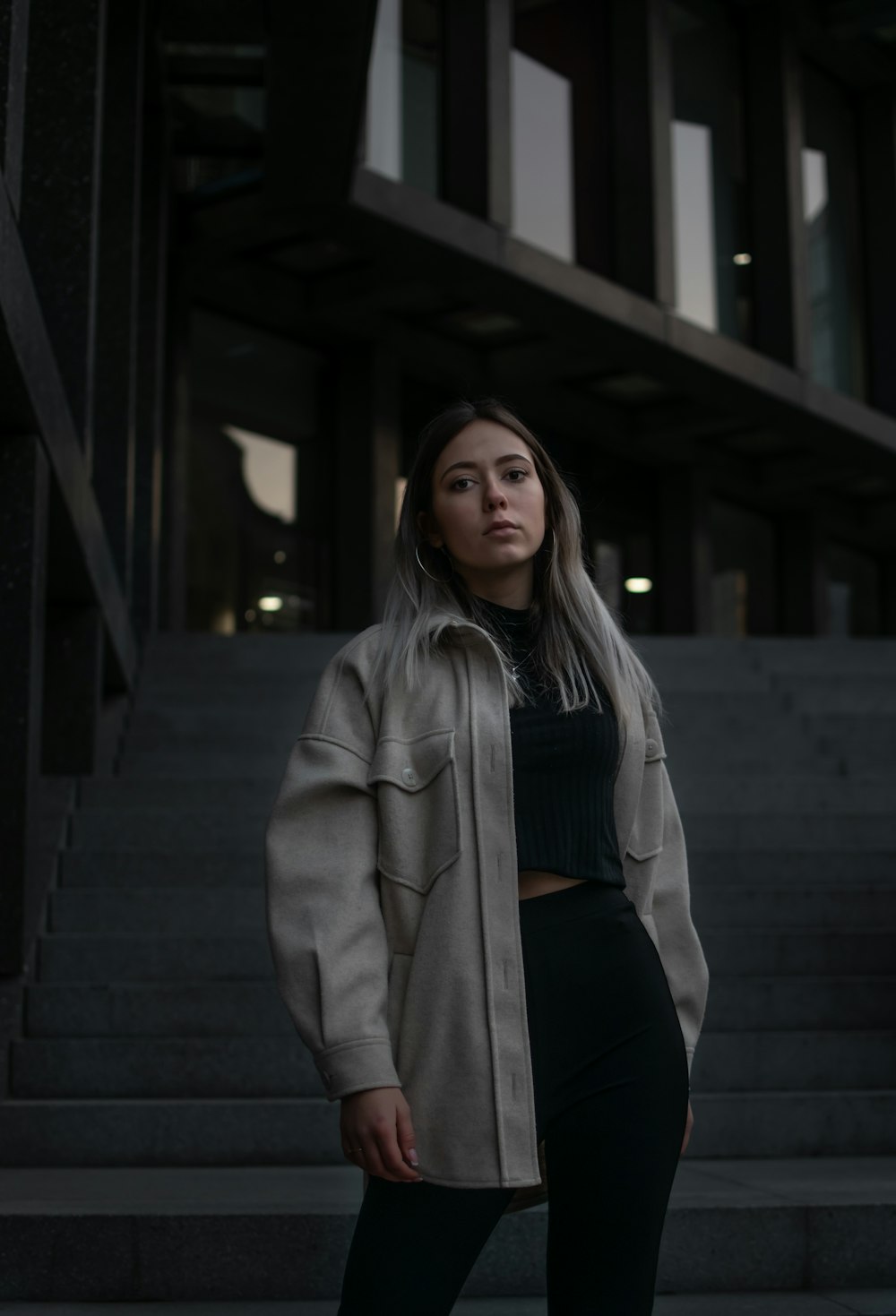 Une femme debout devant des escaliers