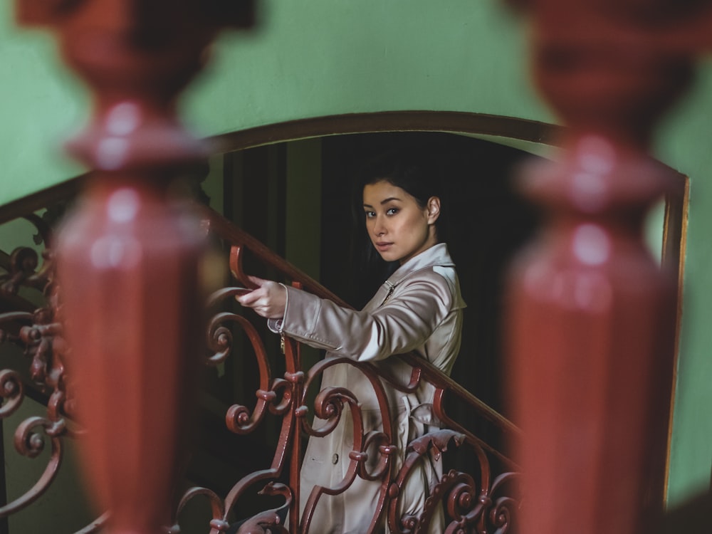 a woman is standing on a balcony railing