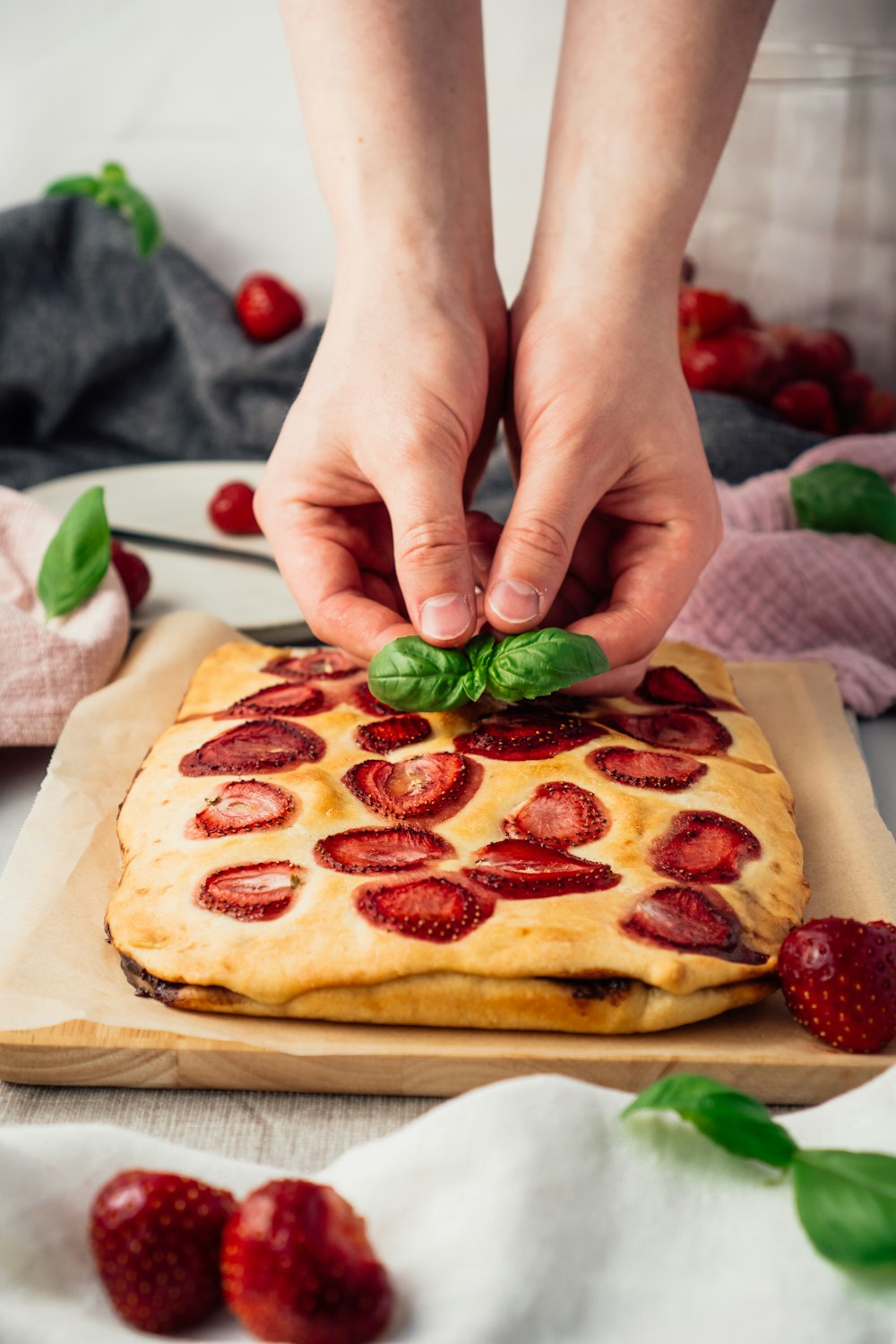 a person is decorating a cake with strawberries