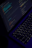 black laptop computer turned on showing microsoft word
