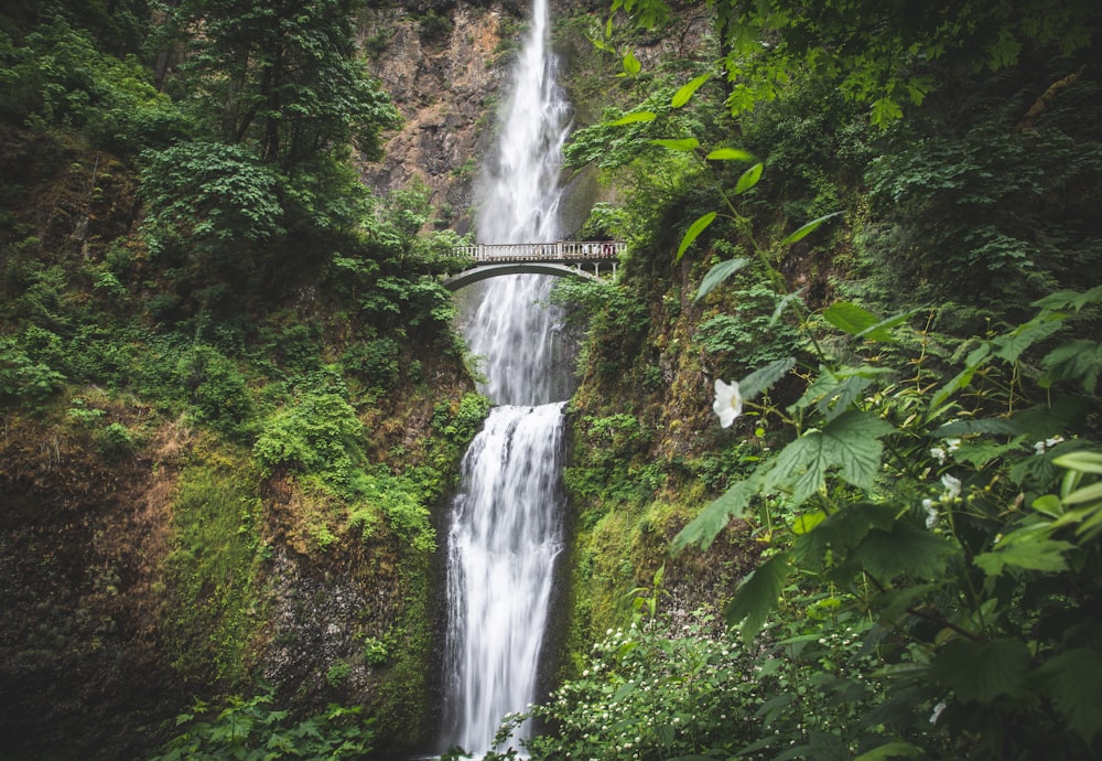 a large waterfall with a bridge over it