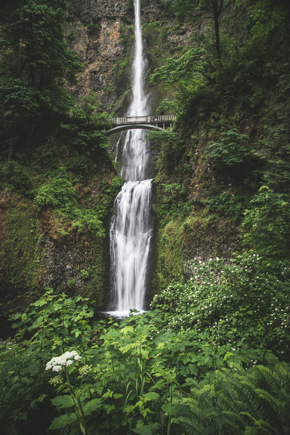 a large waterfall with a bridge over it