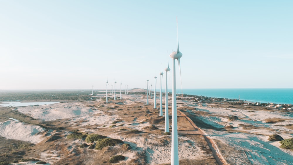 une rangée d’éoliennes assises au sommet d’une plage de sable