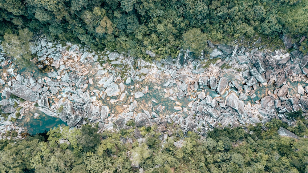 an aerial view of a river surrounded by rocks and trees