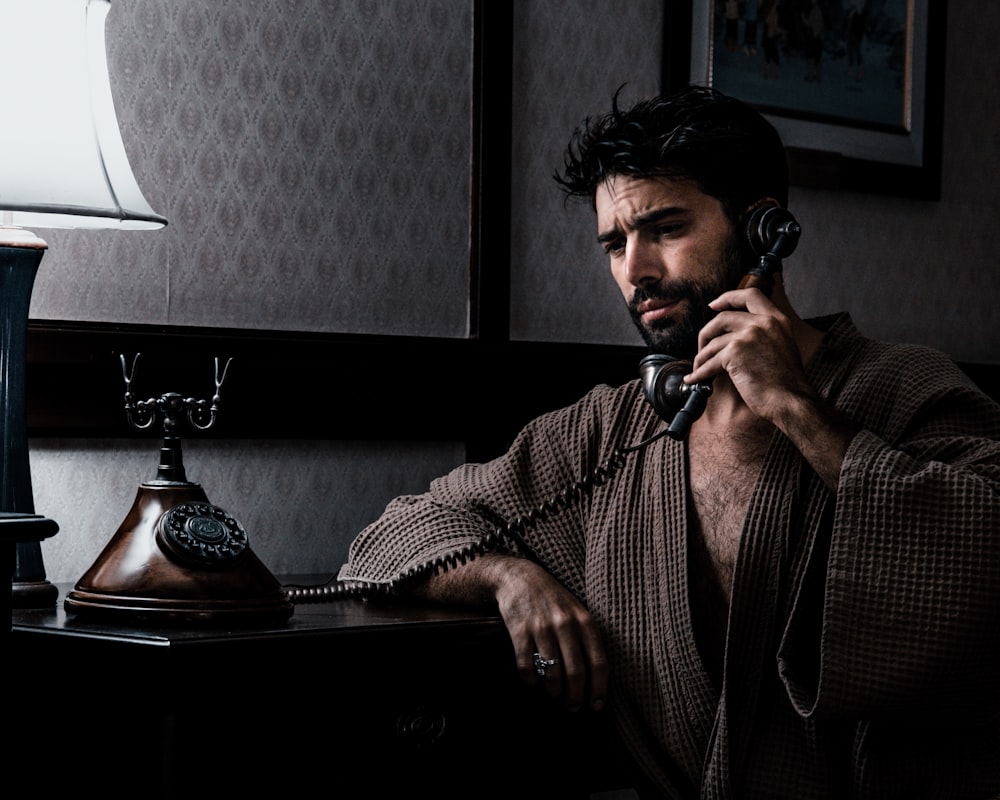 a man sitting at a desk talking on a phone