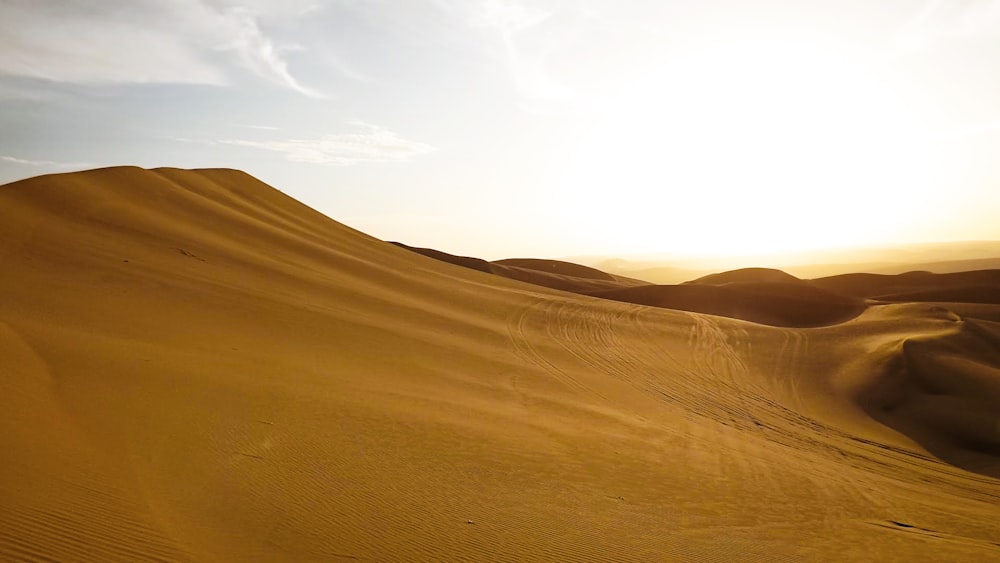 brown sand under white clouds during daytime