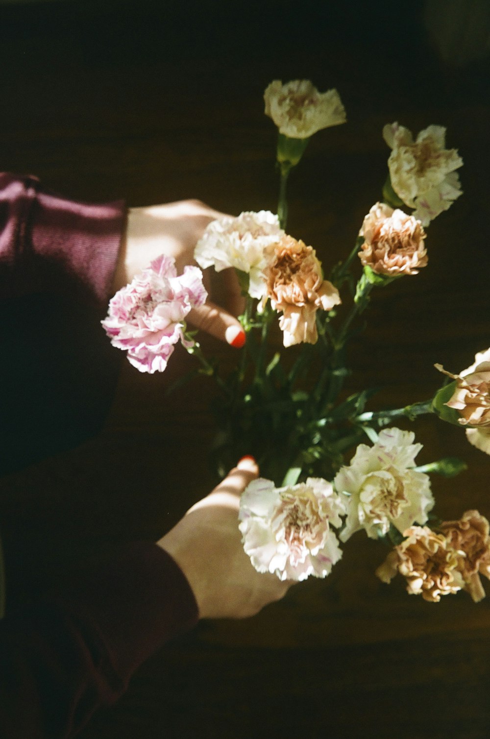 a person holding a bouquet of flowers on a table
