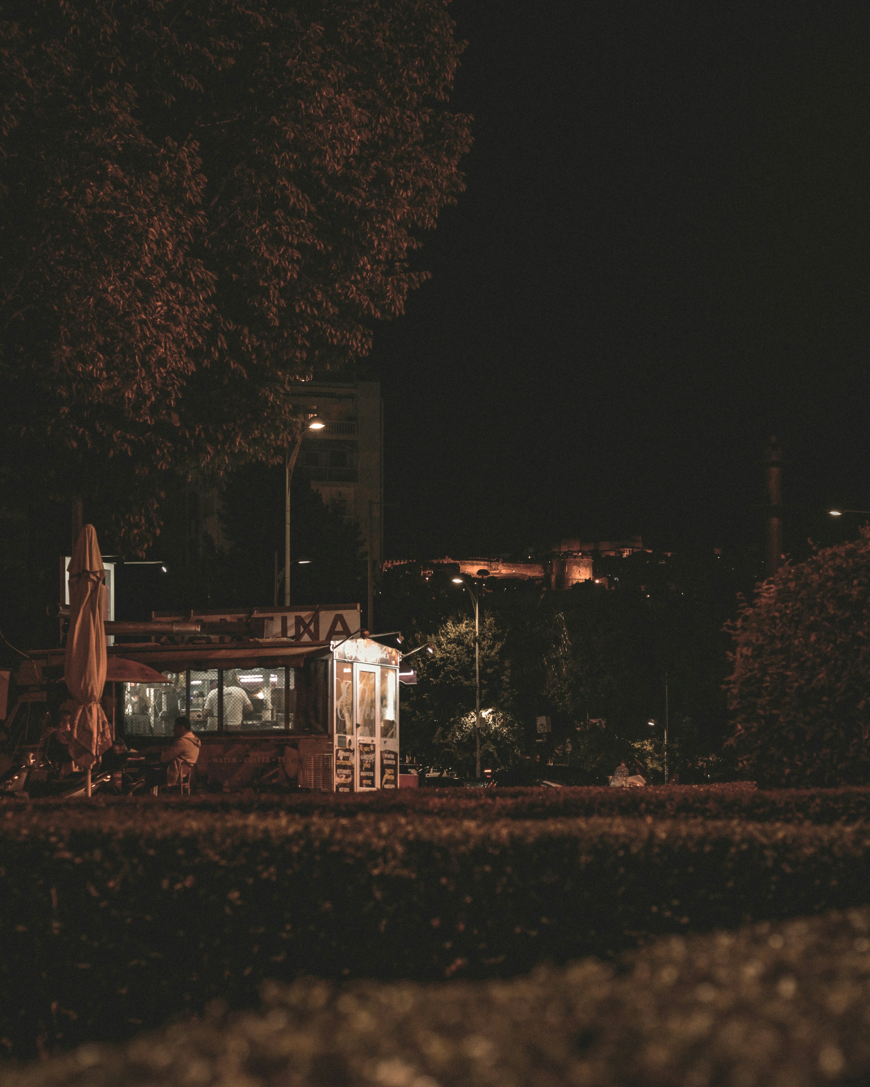 a night time view of a restaurant with trees in the background