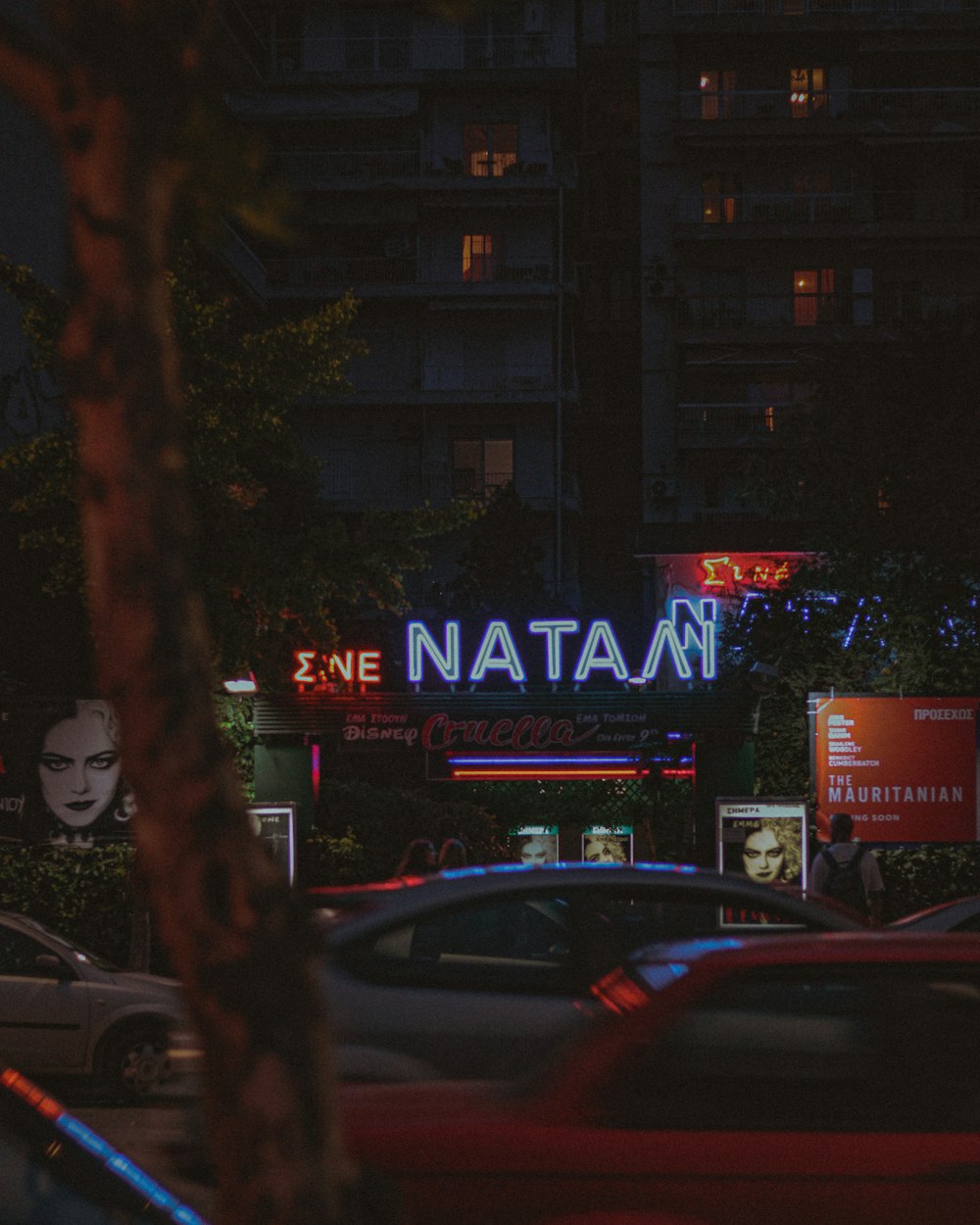 a city street at night with a neon sign