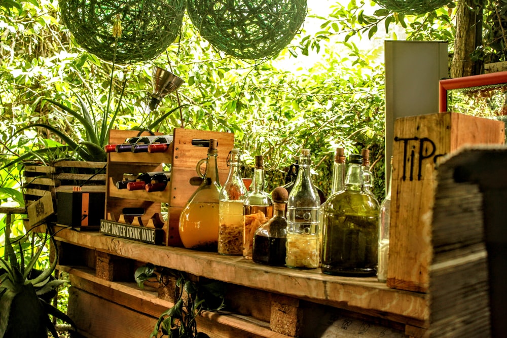 clear glass bottles on brown wooden shelf