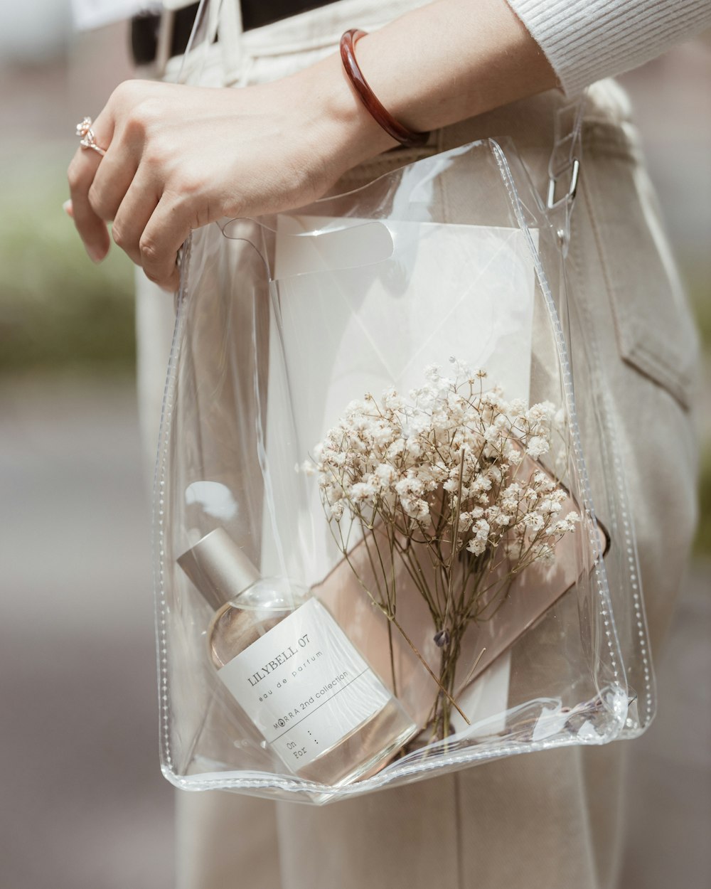 eine Person, die eine durchsichtige Tasche mit Blumen darin hält