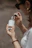 a woman holding a bottle of perfume in her hand