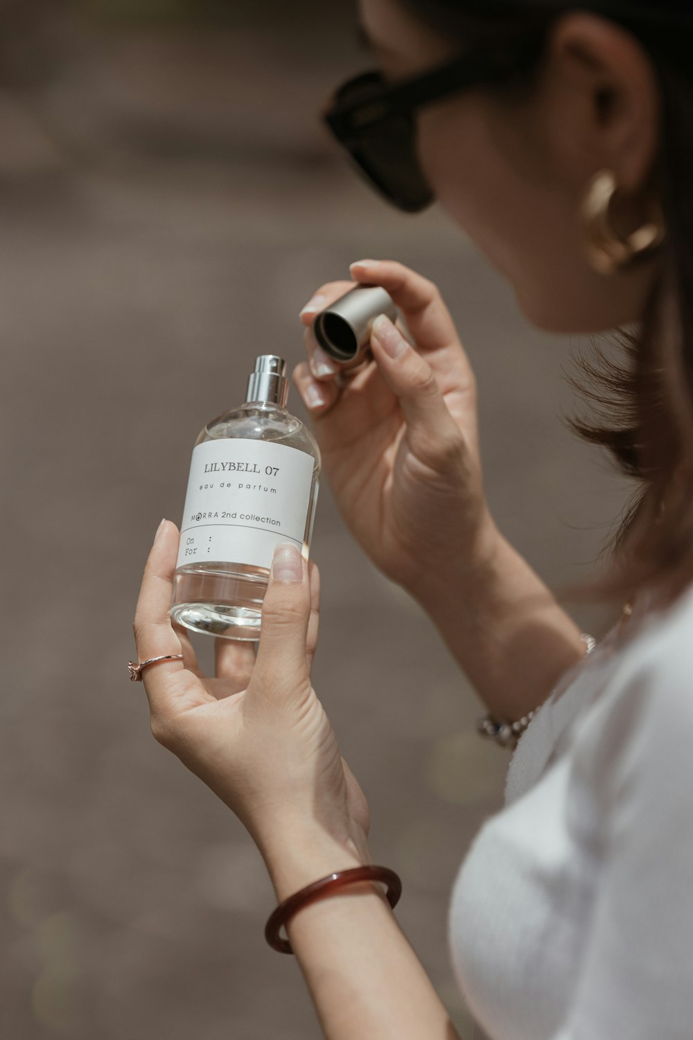 a woman holding a bottle of perfume in her hand