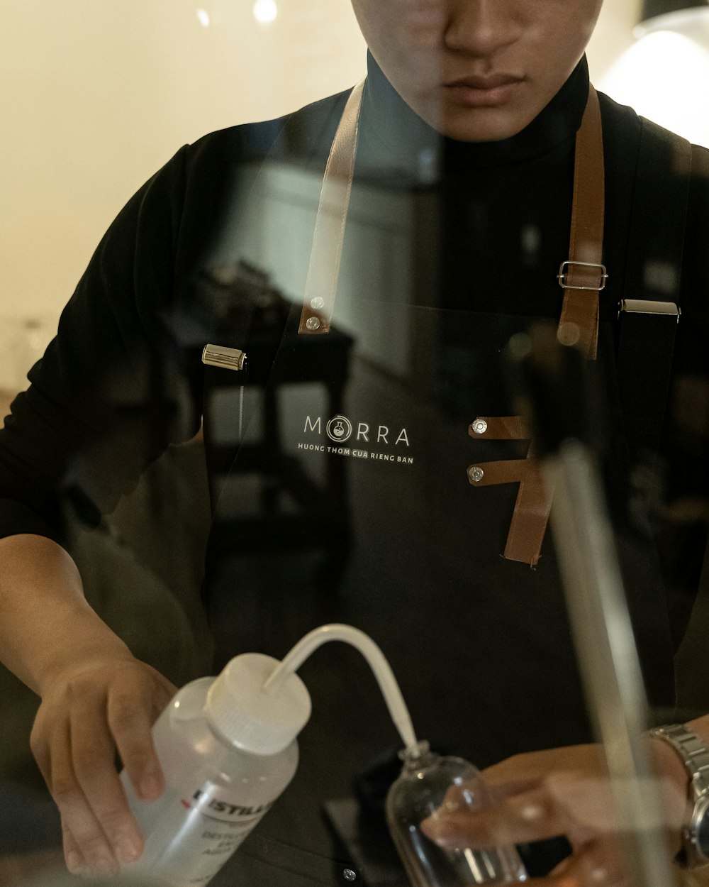 a man in a black shirt is pouring something into a cup