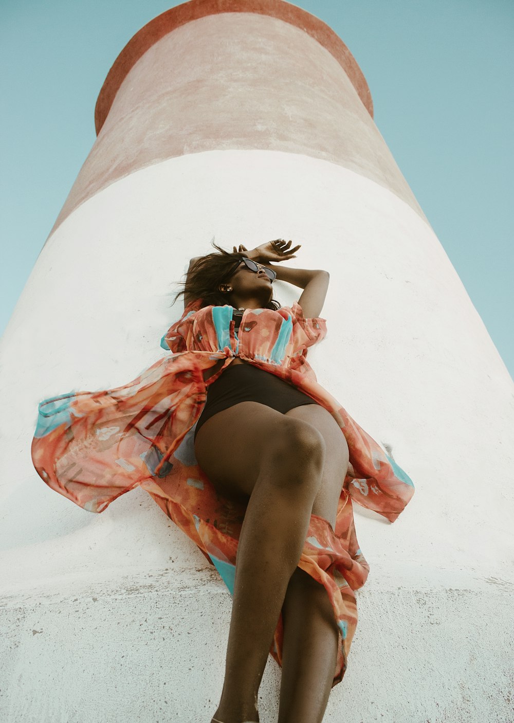 a woman in a dress sitting on a wall