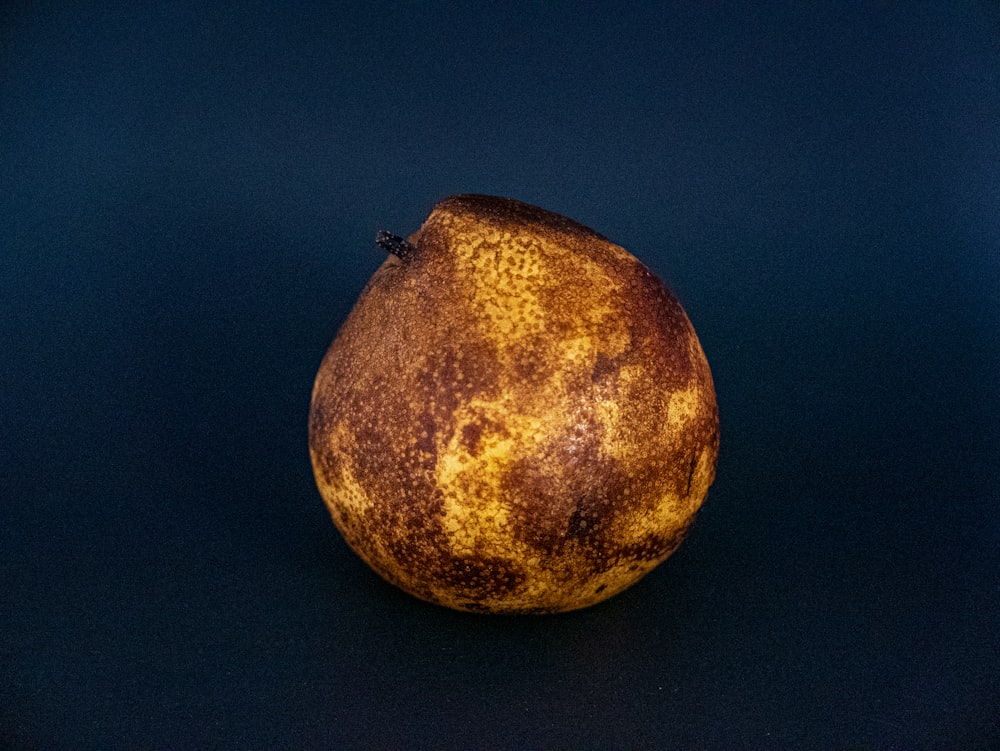 a brown and yellow pear on a blue background