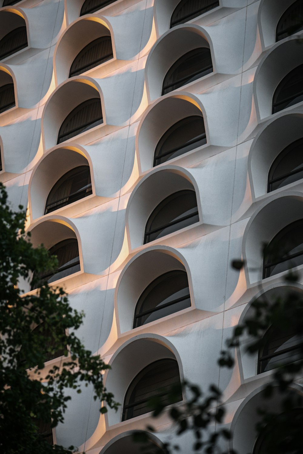 white concrete building near green tree during daytime