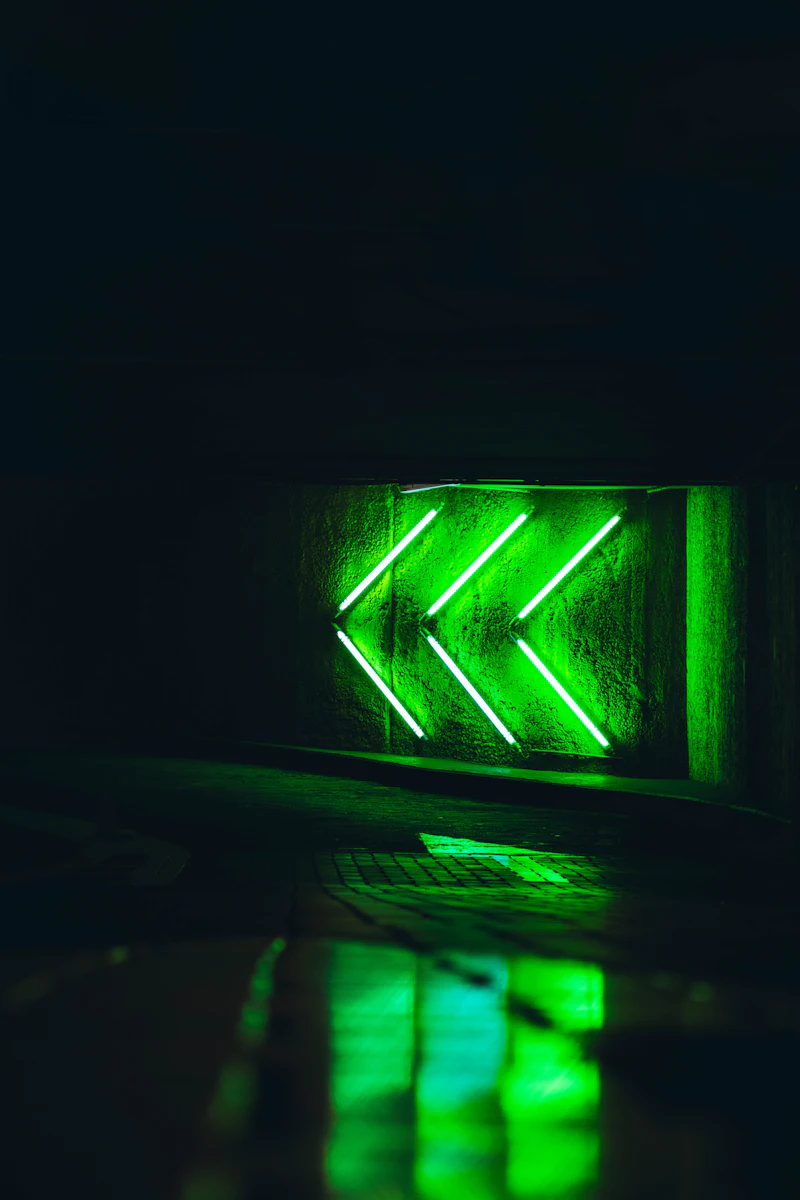Green neon light glowing against a dark city backdrop at night