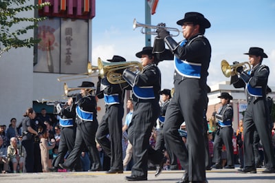 people in black and blue uniform playing musical instruments during daytime parade zoom background