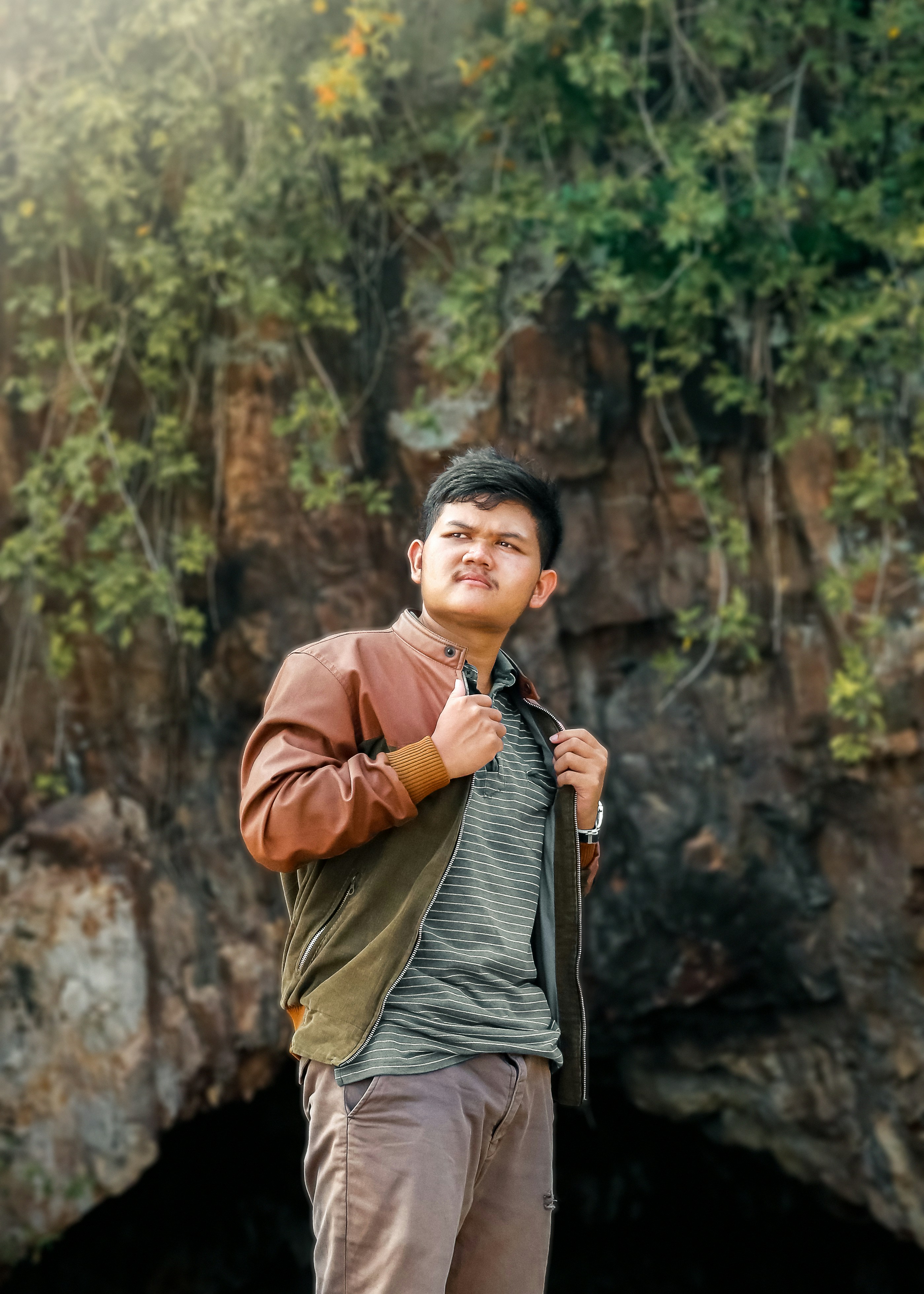 woman in brown jacket standing near brown rock