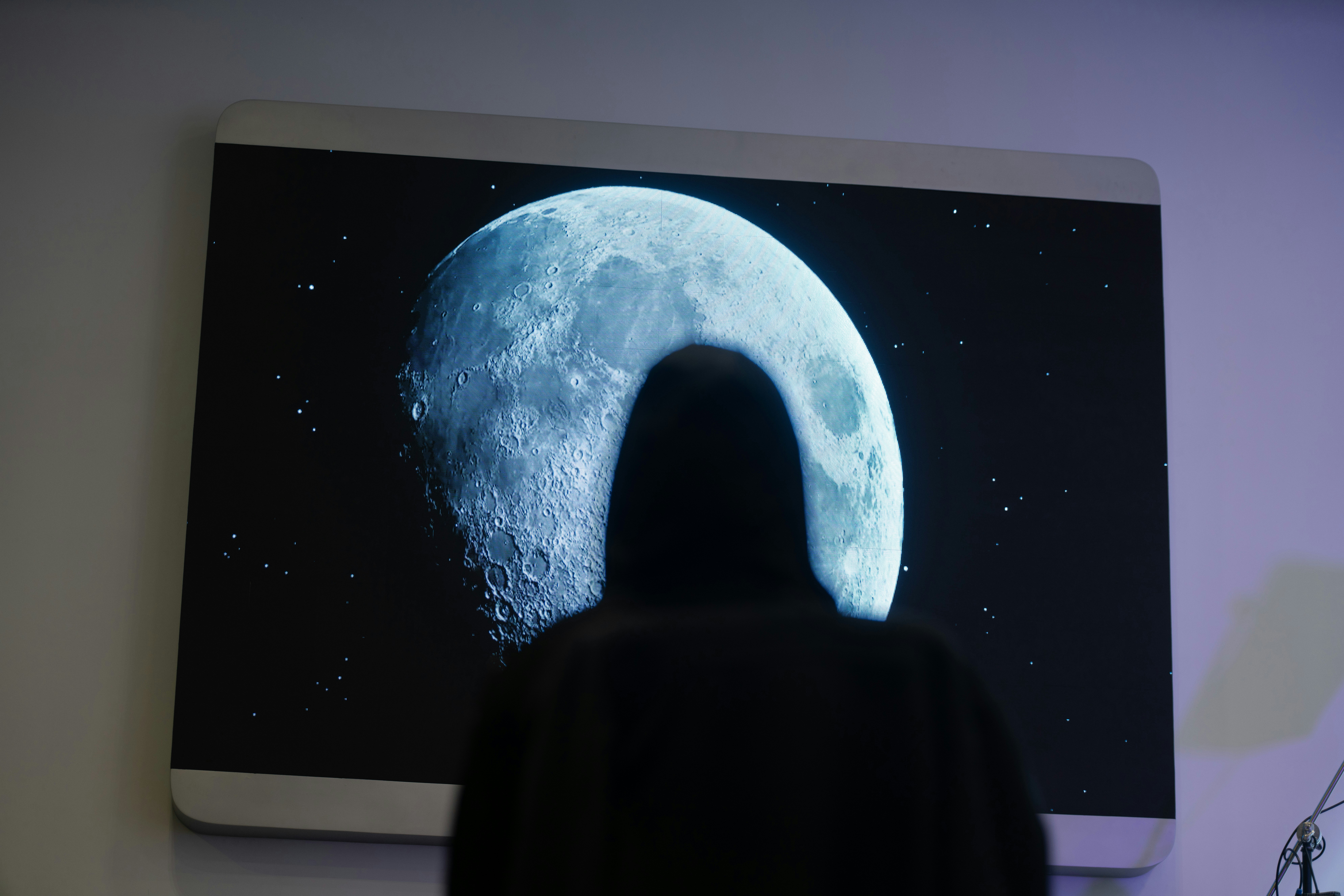 uma pessoa em pé na frente de uma imagem de uma lua
