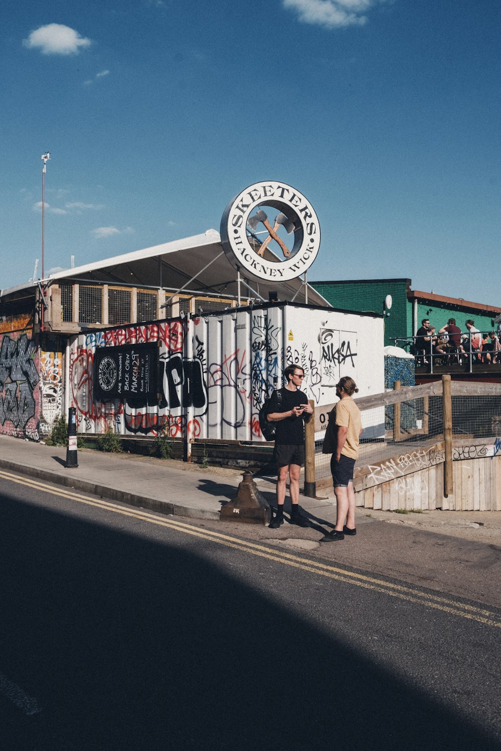 a couple of people standing on the side of a road