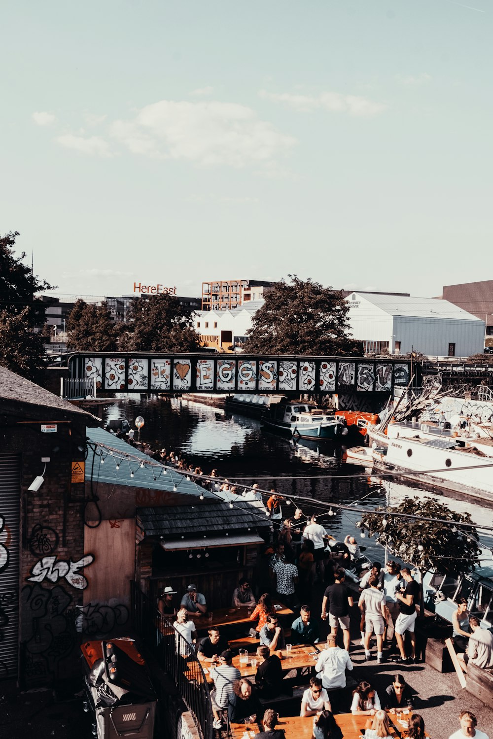 a group of people sitting at tables next to a river