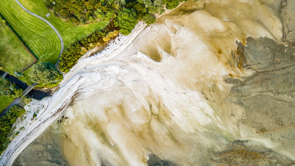 an aerial view of a river running through a lush green field