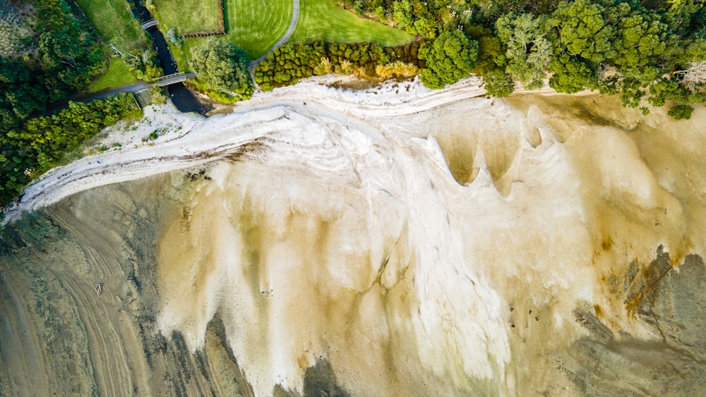 an aerial view of a river running through a lush green forest