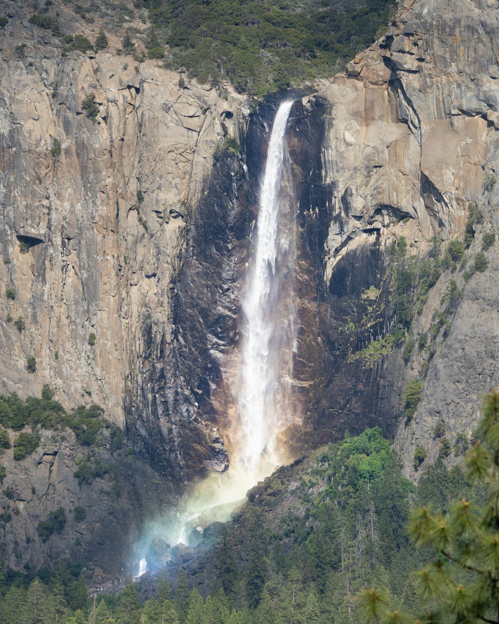 a large waterfall with a rainbow in the middle of it