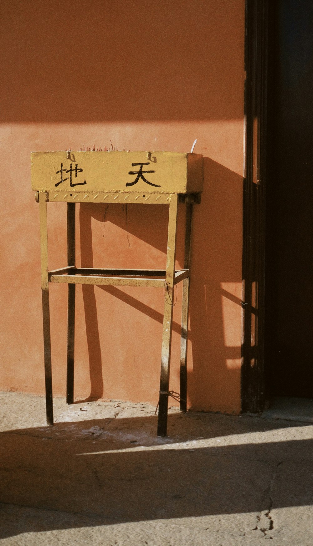 brown wooden ladder leaning on orange painted wall