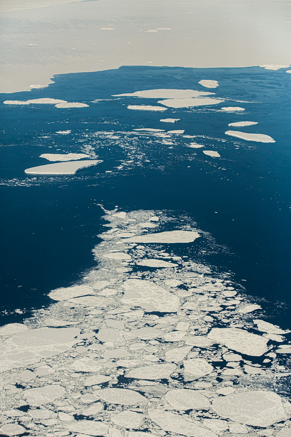 an aerial view of ice floes in the ocean