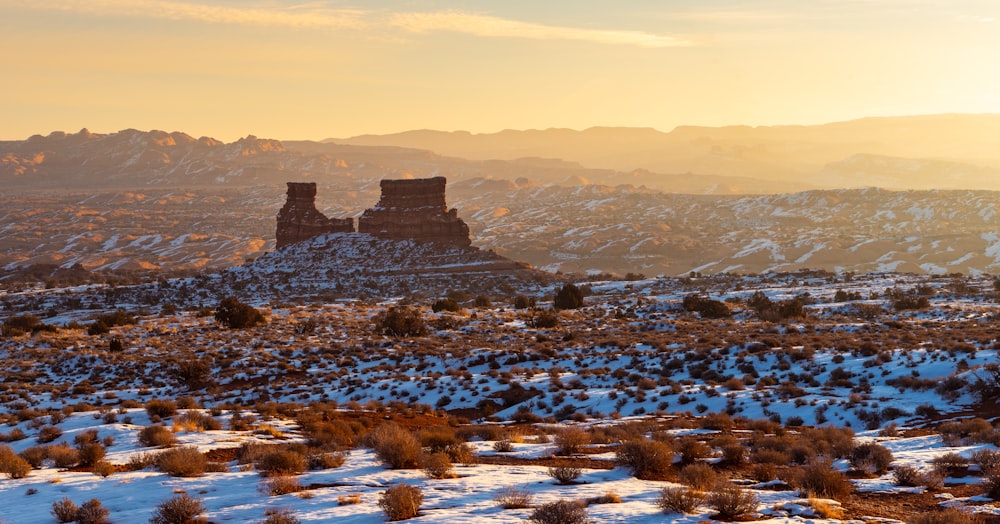 a snow covered landscape with mountains in the background