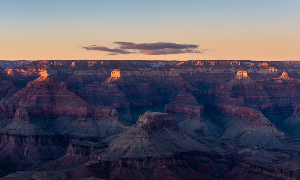 the sun is setting at the edge of the grand canyon