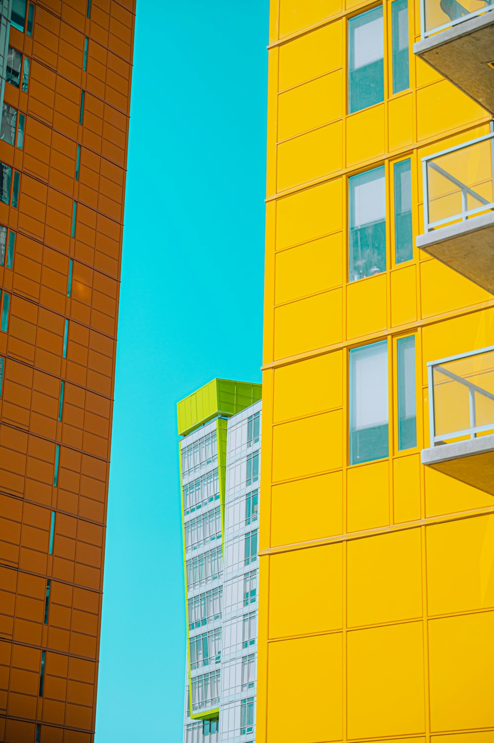 a yellow building next to a tall orange building