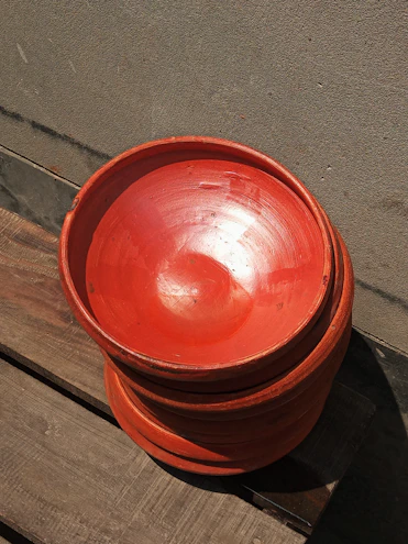 A set of earthy stoneware bowls stacked neatly, showcasing their raw clay texture and subtle color variations.