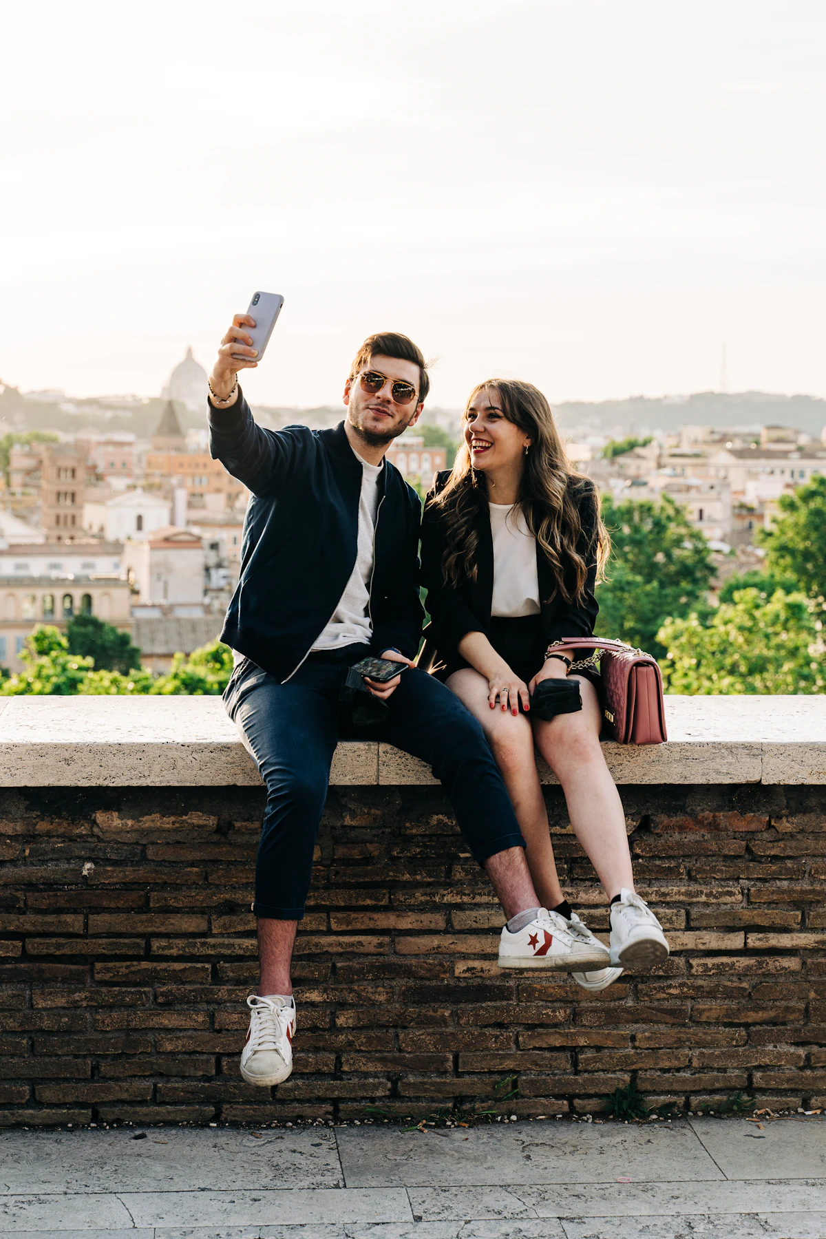 Two friends taking a selfie above a city