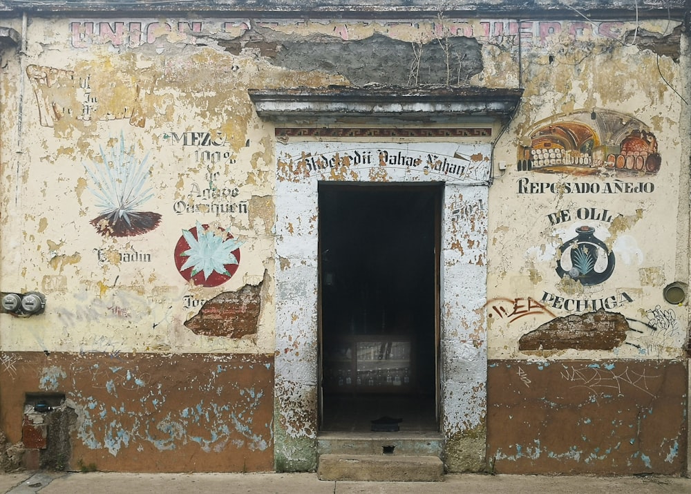 ein altes Gebäude mit einer Tür und einigen Schildern