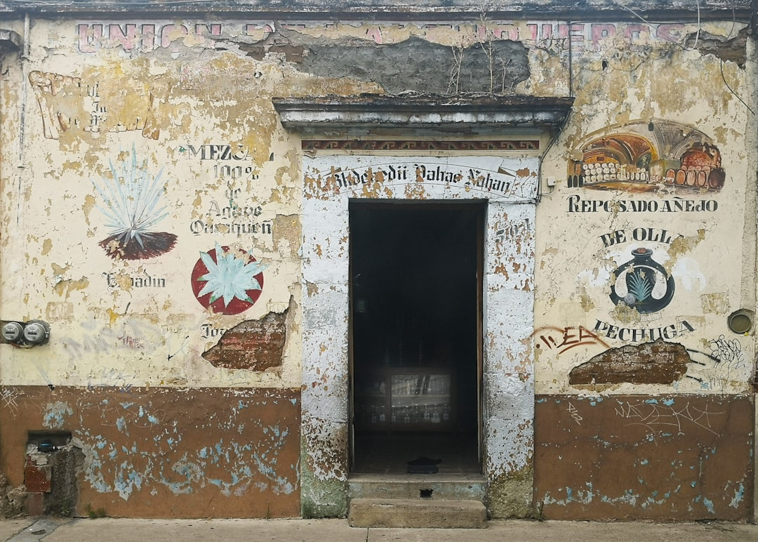 an old building with a door and some signs on it, Building in Oaxaca City.